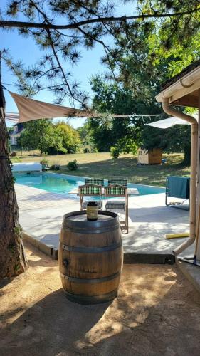 un grand tonneau en bois assis à côté d'une piscine dans l'établissement Chambre d'hôte à 