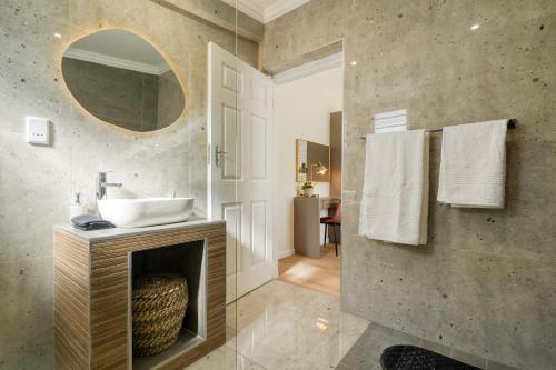 a bathroom with a sink and a mirror at Hampton Collection Modern 1 or 2 Bedroom Apartment with Pool in Durban