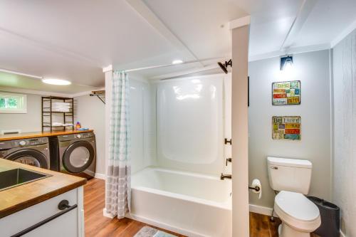 ein Badezimmer mit einer Badewanne und einer Waschmaschine in der Unterkunft Cozy Clarkesville Getaway with Fire Pit! in Clarkesville