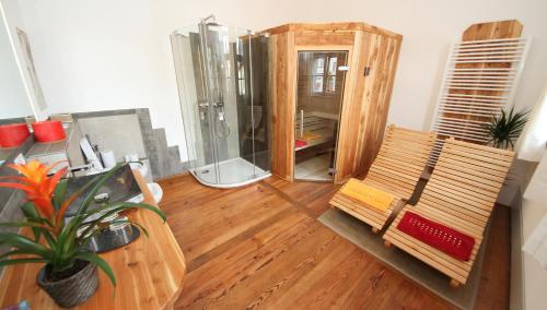 een badkamer met een douche en een houten vloer bij Altstadtpalais im Sand in Bamberg