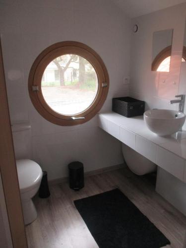 een badkamer met een toilet, een wastafel en een raam bij Proche plage et marché, grand jardin, barbecue 9 pers in La Baule
