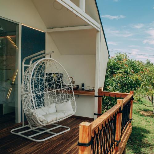 a porch with a rattan chair on a balcony at Örök Hotel in Rionegro
