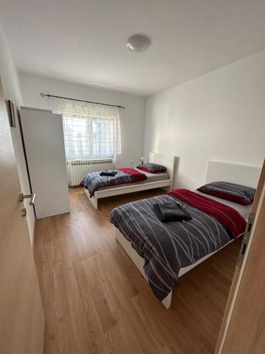 een slaapkamer met 2 bedden en een raam bij Kuća za odmor Ruža in Nuštar