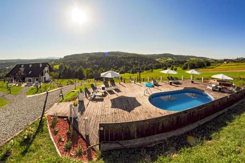 una terrazza in legno con vista sulla piscina. di Chata w Bieszczadzie widokowe apartamenty w Bieszczadach a Polańczyk