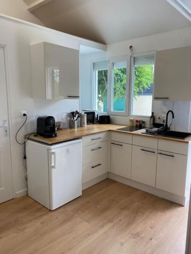 une cuisine avec des armoires blanches et un plancher en bois dans l'établissement Proche Paris et Disney-calme absolu, à Vaires-sur-Marne