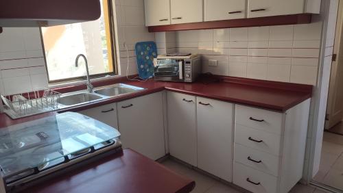 a small kitchen with a sink and a microwave at Club Playa Blanca in Playa Blanca