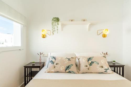 ein Schlafzimmer mit einem Bett mit zwei Kissen in der Unterkunft Casa La Fontana 1 in Vejer de la Frontera