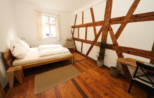 um quarto com uma cama, pisos em madeira e uma janela em Altstadtpalais im Sand em Bamberg