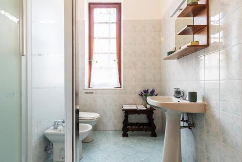 a white bathroom with a sink and a toilet at Decana Flexyrent Apartment in Genova