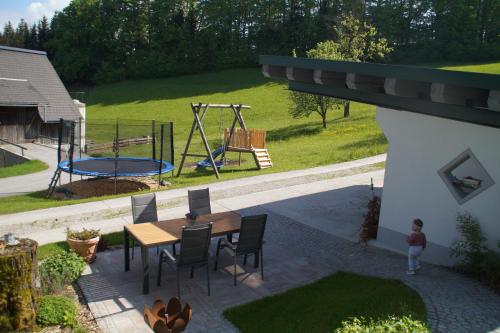 un patio con tavolo, sedie e parco giochi di Ferienhaus Zwickelreith a Göstling an der Ybbs