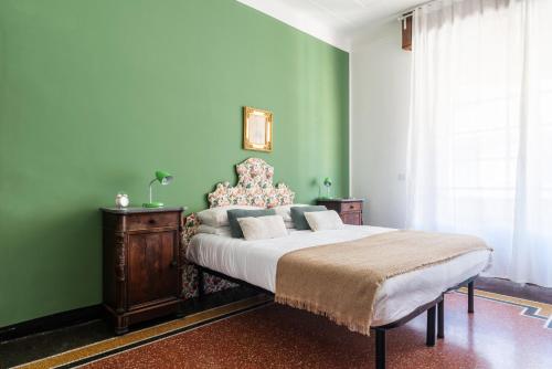 a bedroom with a large bed with green walls at Decana Flexyrent Apartment in Genoa