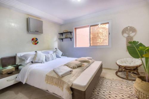 a bedroom with a large white bed and a window at Luxury Duplex - Private Jacuzzi - Center Hivernage in Marrakech