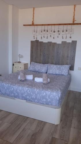 a bedroom with a large bed with a wooden headboard at GLP RISCAL 2 in Alicante