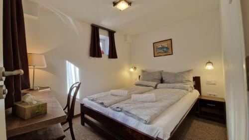 a bedroom with a bed and a table with a lamp at Red Lion Pub & Apartments Szentendre in Szentendre