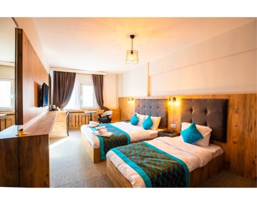OTEL374 في بولو: غرفة فندق بسريرين مع وسائد زرقاء