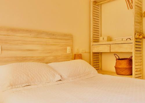 a bedroom with a white bed and a mirror at Petite Suite Juquehy - A 2 quadras do Mar - Pequena mas completa - 13 metros quadrados - Ar cond - Frigobar - Microondas - TV Smart - Serviço de Praia - Roupa cama e banho luxo - Wi Fi - Janelas e portas acústicas - Tudo Novo e cheiroso! in Juquei