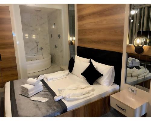 a room with a bed with towels and a tub at OTEL374 in Bolu