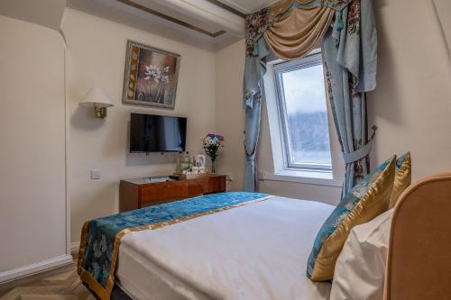 a bedroom with a large bed and a window at Muthu Fort William Hotel in Fort William