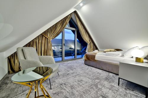 a bedroom with a bed and a large window at Kompleks Gazdówka Apartamenty - Rabka-Zdrój in Ponice