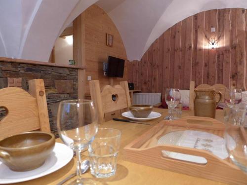 a wooden table with wine glasses on top of it at Appartement de charme "Chalet Jacky" suréquipé à 300m des pistes et du centre village in Saint-Martin-de-Belleville