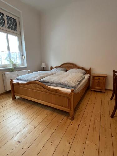 a bedroom with a bed and a wooden floor at Appartement Antikverliebt Aken in Aken