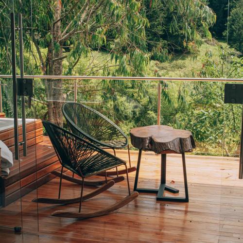 a chair and a table on a deck with a tree at Örök Hotel in Rionegro