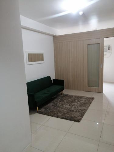 een woonkamer met een zwarte bank en een tapijt bij SHORE Residences Near MOA in Manilla