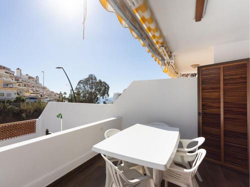 a white table and chairs on the balcony of a building at Live cardon las americas con piscina y terraza in Arona