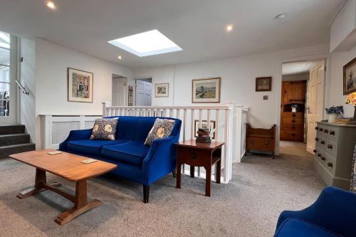 a living room with a blue couch and a table at Charming Galloway cottage near Kirkcudbright in Twynholm