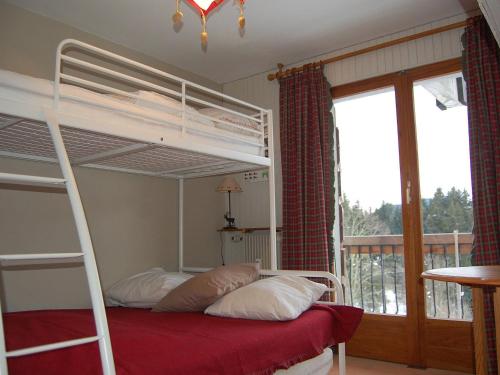 - une chambre avec 2 lits superposés et un balcon dans l'établissement Appartement cosy, proche des pistes, stationnement, balcon, TV, et équipement cuisine complet - FR-1-623-167, aux Gets
