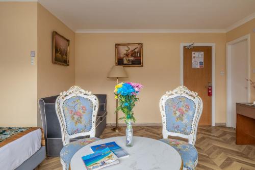 a room with two chairs and a table with a vase of flowers at Muthu Fort William Hotel in Fort William