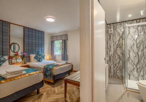 a hotel room with two beds and a bathroom at Muthu Fort William Hotel in Fort William