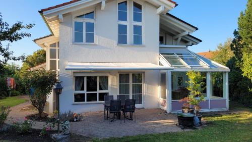 a white house with a patio and chairs at Ferienhaus Elisabeth in Leutkirch im Allgäu