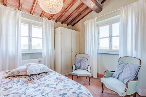 盧卡的住宿－Anna Farmhouse at Wine Resort，一间卧室配有两把椅子和一张床,设有窗户。