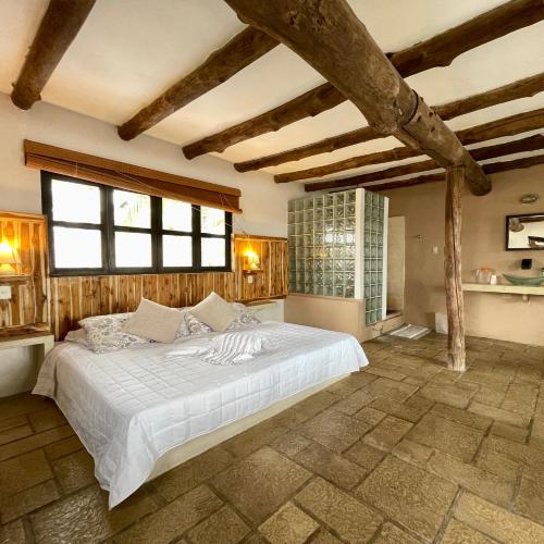 a bedroom with a large bed in a room with wooden ceilings at Johnnys Place Hotel in Monterrico