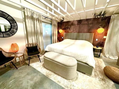 a bedroom with a white bed and a chair at Zen.Modern.Hip “Studio 501” Beach,Scuba,Downtown in West Palm Beach