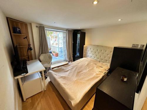 Habitación pequeña con cama y ventana en Grade II Listed Balconied 3-Bed Mezzanine Kensington Flat, en Londres