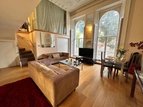 sala de estar con sofá y mesa en Grade II Listed Balconied 3-Bed Mezzanine Kensington Flat, en Londres
