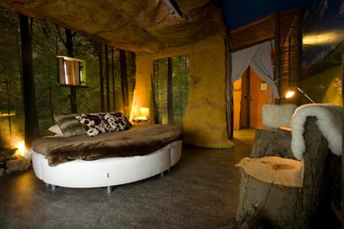 ein Schlafzimmer mit einem Bett in einem Zimmer mit Bäumen in der Unterkunft City Hotel Restaurant Stadskanaal in Stadskanaal