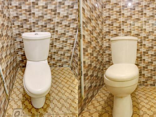 a bathroom with a toilet and a shower at SPOT ON 92985 Mitra Homestay in Nagoya