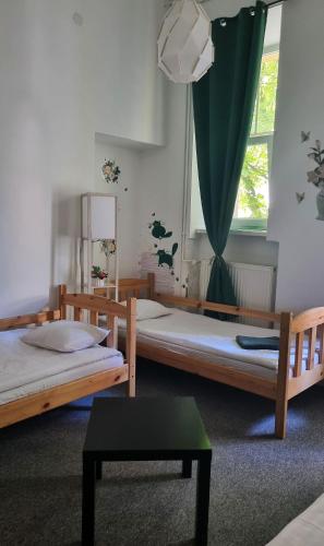 a room with two beds and a window at Green Cat Rooms in Krakow
