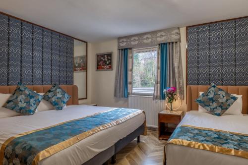 a bedroom with two beds and a window at Muthu Fort William Hotel in Fort William