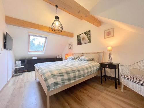 um quarto com uma cama, uma mesa e uma janela em De Lelie em Rekem
