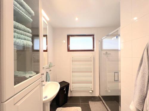 uma casa de banho branca com um lavatório e um WC em De Lelie em Rekem