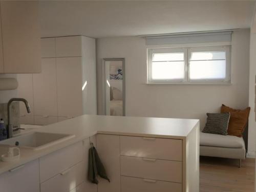 a white kitchen with a sink and a window at Moderne Studio Ferienwohnung in Bad Doberan in Bad Doberan