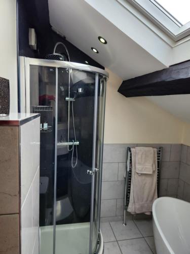 a bathroom with a shower with a glass shower stall at The Garden Bar Rooms in Baildon