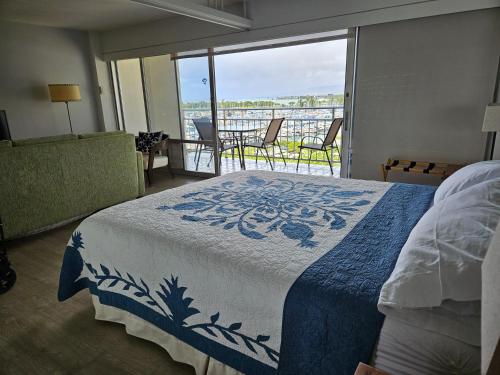 a bedroom with a bed and a balcony with a view at Ilikai Hotel Condo with Kitchen and Ocean View in Honolulu