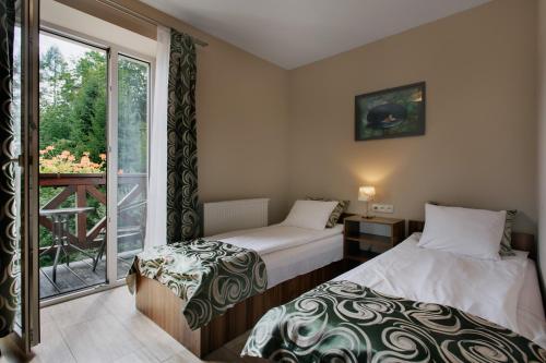 dwa łóżka w pokoju z oknem w obiekcie Antracyt w mieście Krynica Zdrój