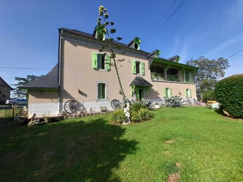 Casa grande con ventanas verdes en un patio verde en Ferme Arboucau, en Peyrouse