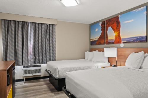a hotel room with two beds and a large window at Days-Inn by Wyndham Albuquerque I-25 in Albuquerque